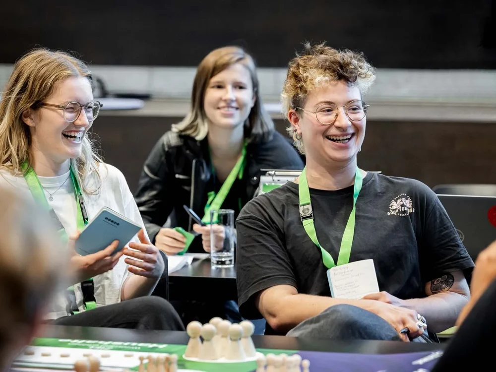 Lachende Gruppe beim Ecomamia spielen